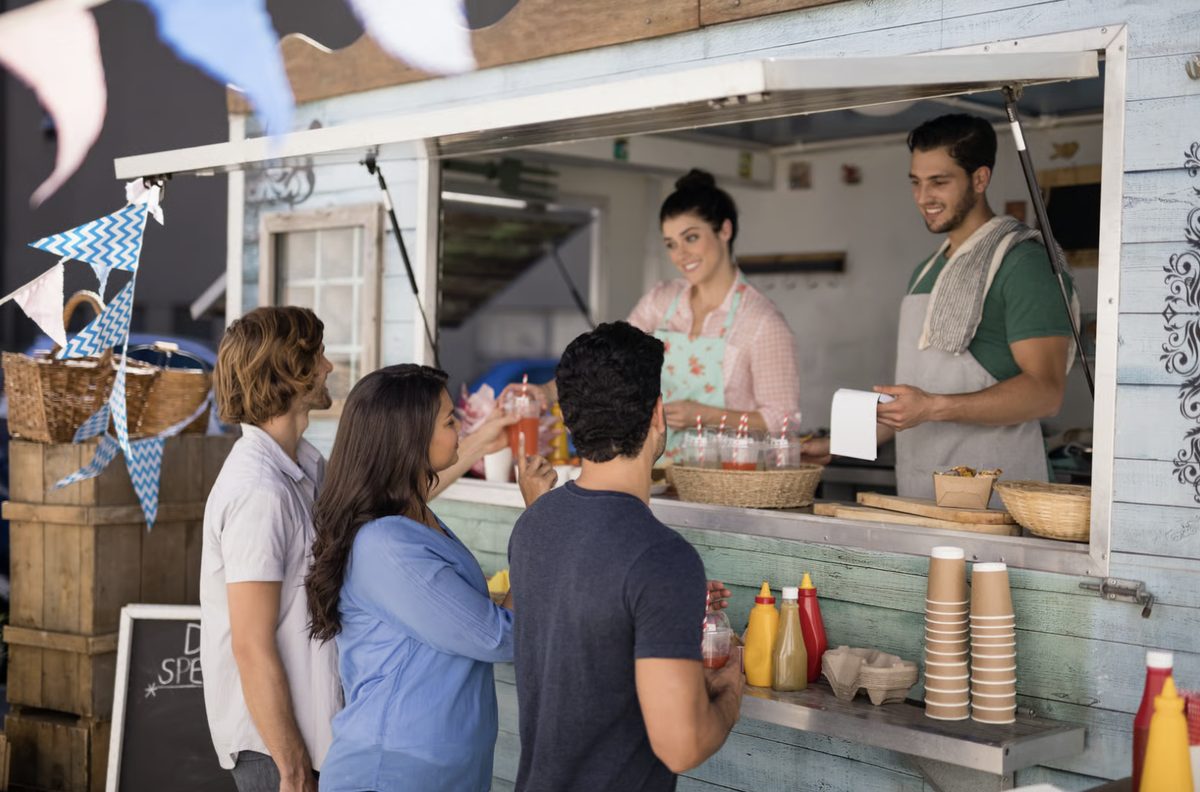 Customers ordering at the window of a food truck