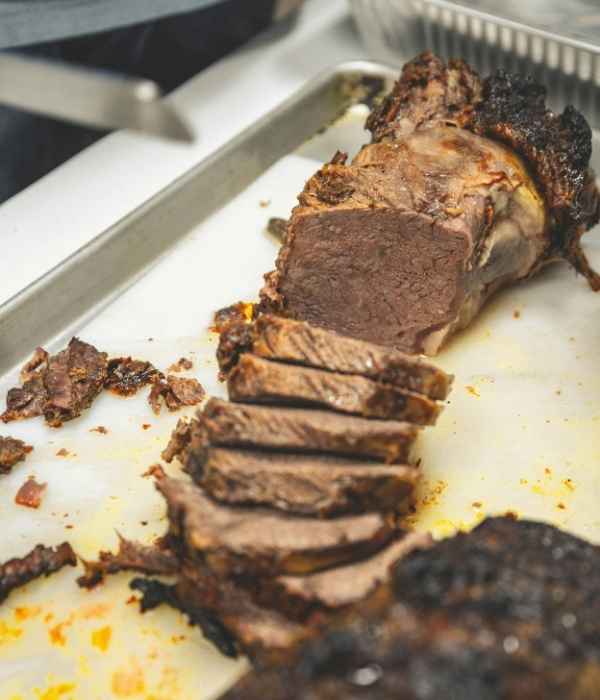 A sliced roast resting on a sheet tray